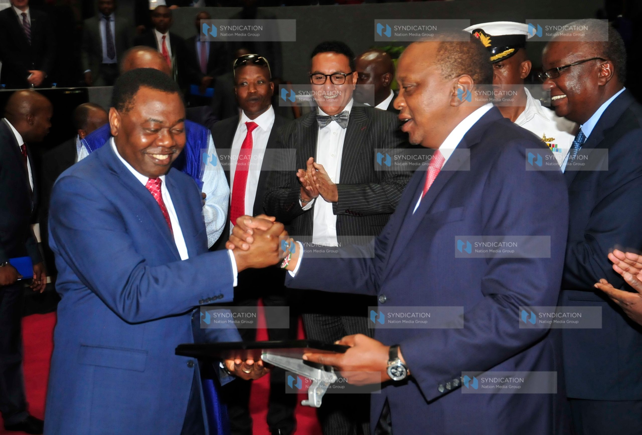 President Uhuru Kenyatta receives a commemorative plaque