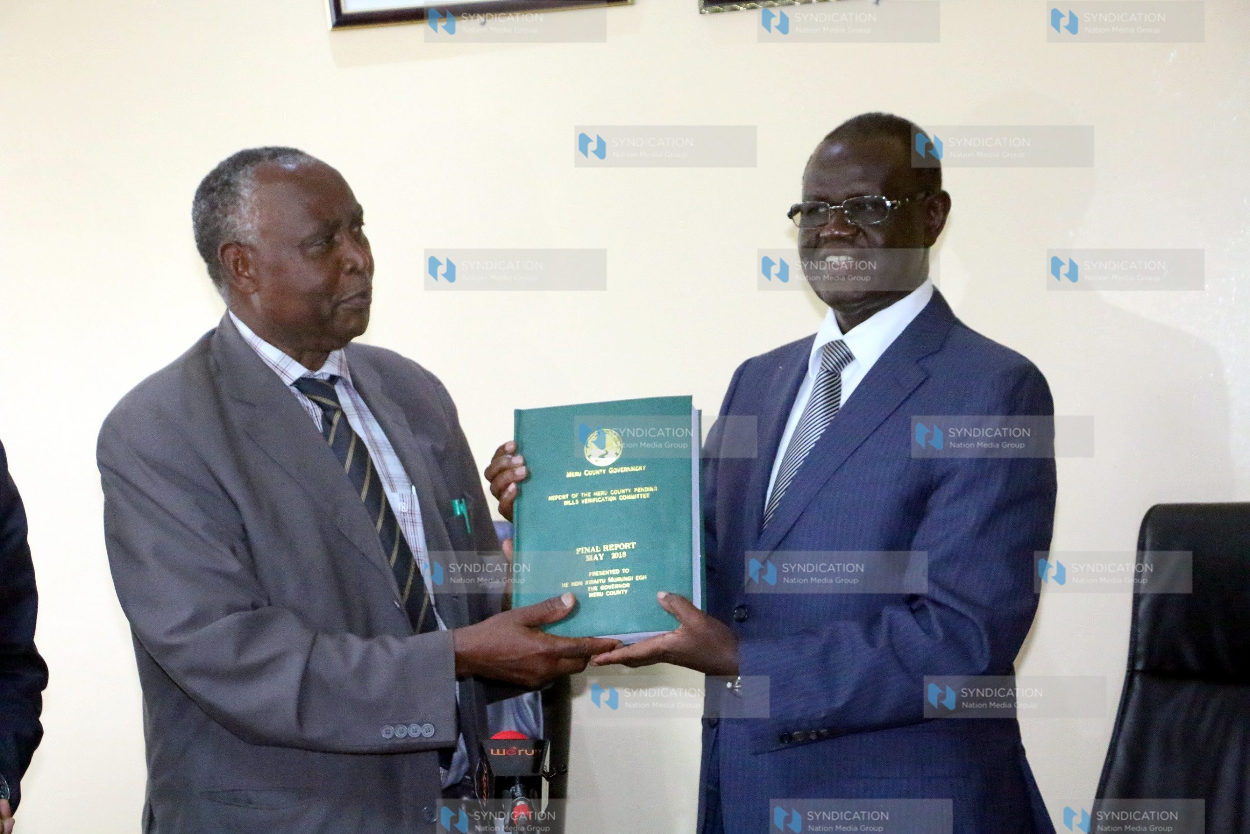 Meru governor Kiraitu Murungi (Right) receives the pending bills report