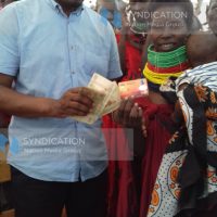 Devolution CS Mwangi Kiunjuri hands Emmy Ekiru cash and a Drought Emergency Scale-up card