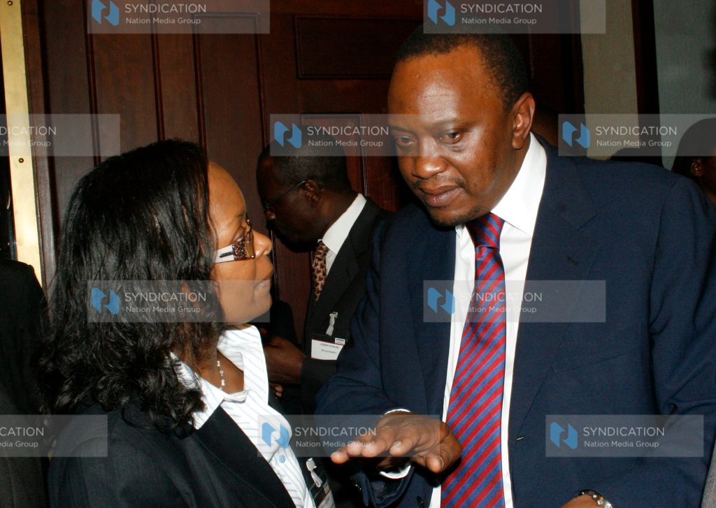 Deputy Prime Minister and Minister for Finance Uhuru Kenyatta speaks with Capital Markets Authority Chief Executive Officer Stella Kilonzo