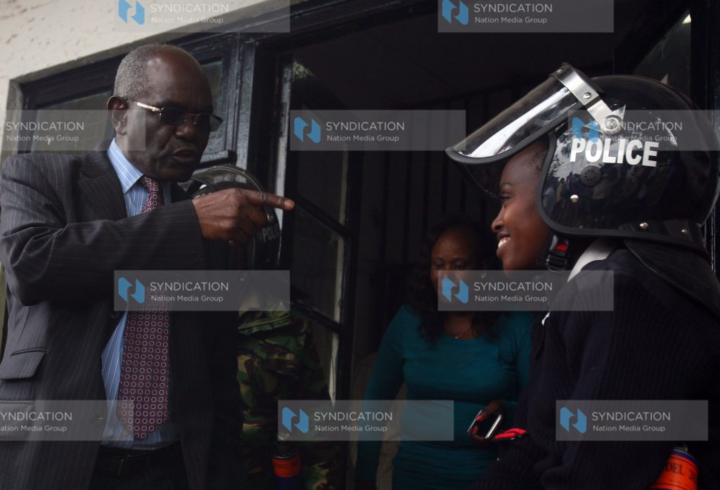 Kitui Senator David Musila speaks with a police officer