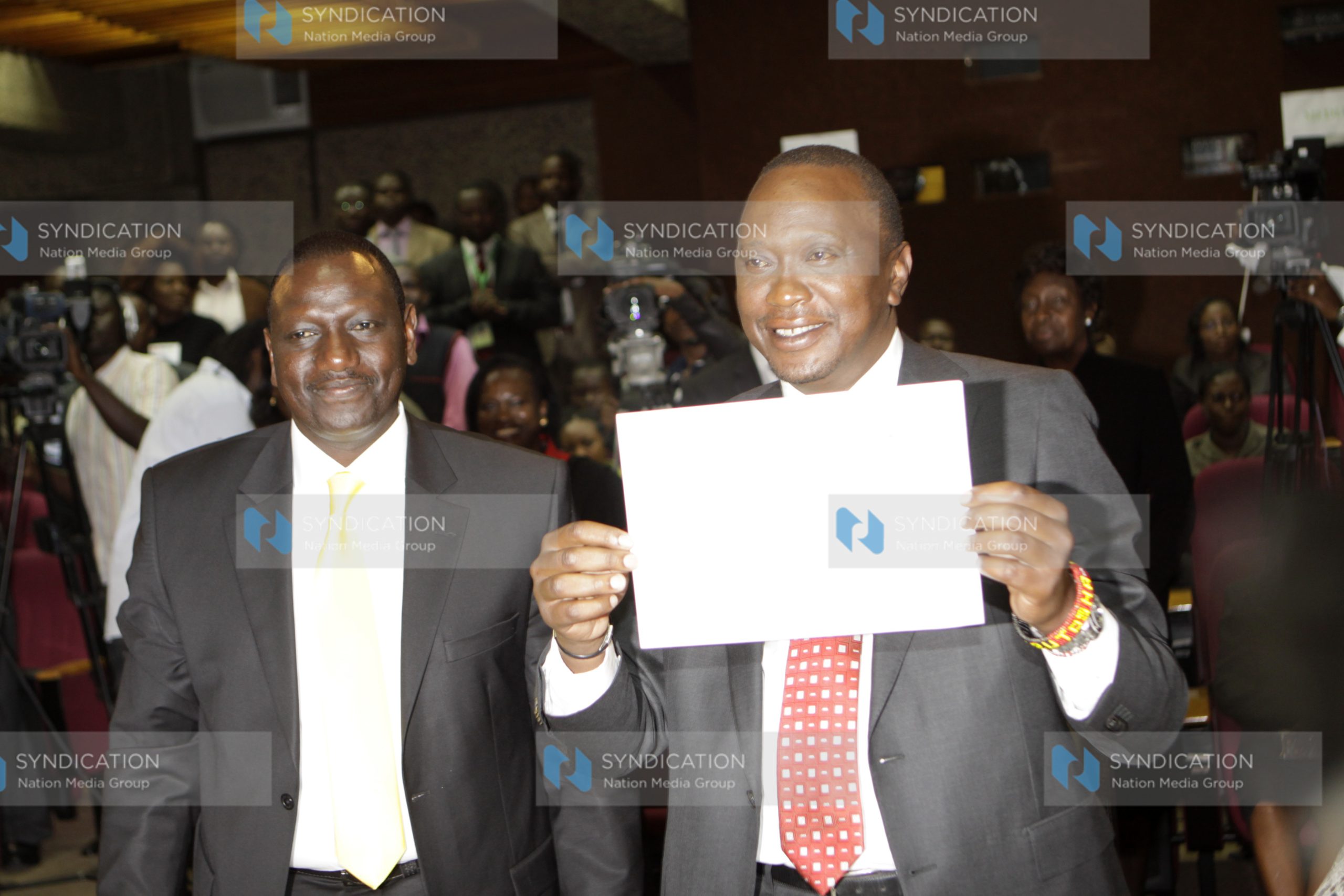 Uhuru Kenyatta shows off his certificate with his running mate William Ruto