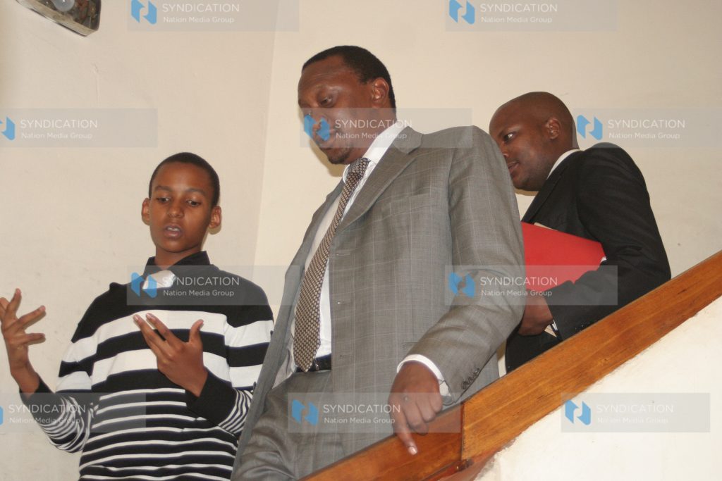 Junior sergeant-at-arms Tevin Waiguru, chats with finance minister Uhuru Kenyatta