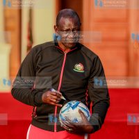 President William Ruto signs a football during the flagging off of the Junior Starlets football team