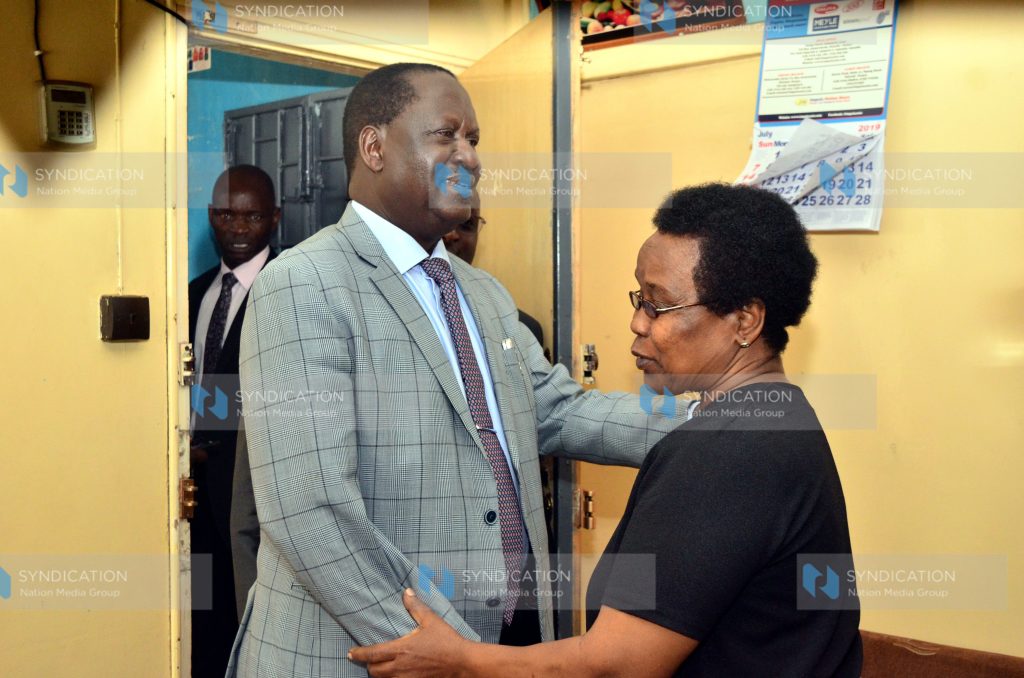 ODM party leader Raila Odinga is welcomed by Mary Kangethe Kadenge, wife of the late football legend Joe Kadenge