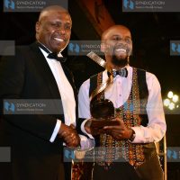 Baringo Senator Gideon Moi presents the Best Original Screenplay Award to Mugambi Nthiga