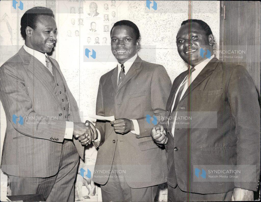 Mwangi Kariuki popularly known as JM in his Nairobi office presenting a cheque for 1,000/=