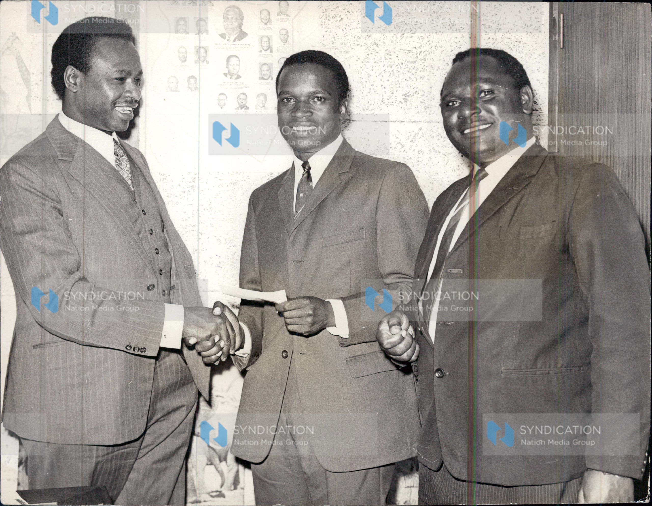 Mwangi Kariuki popularly known as JM in his Nairobi office presenting a cheque for 1,000/=