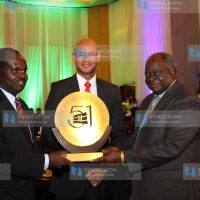 Former President Mwai Kibaki (R) receives a token of appreciation