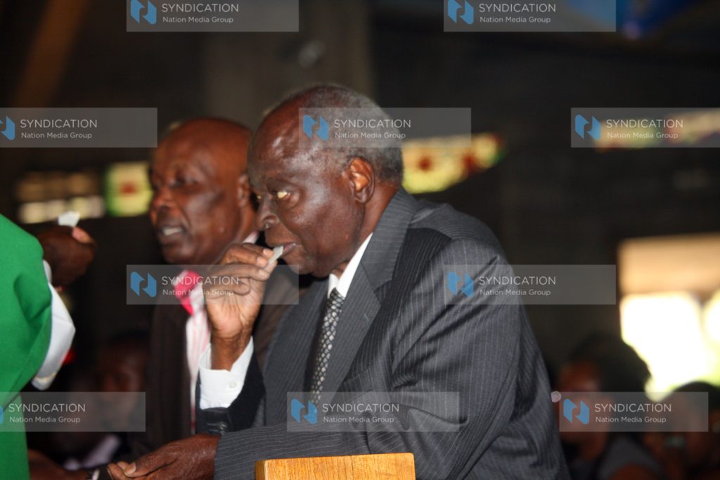Mwai Kibaki partaking a sacrament at Consolata Shrine