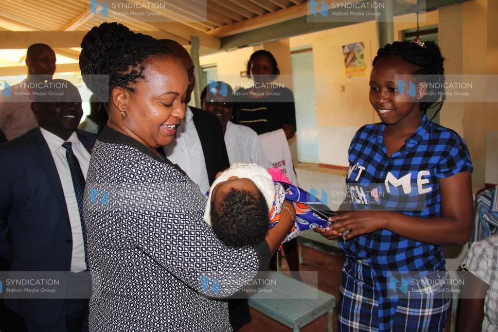 Anne Waiguru holds a baby at Kimbimbi Hospital