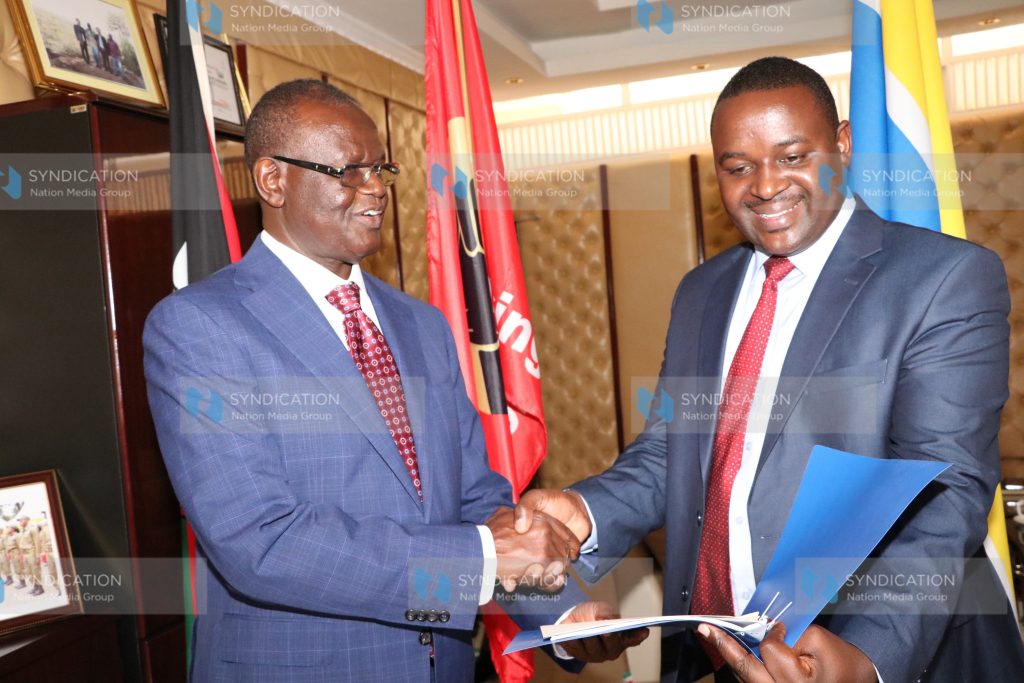 Kiraitu Murungi presents the new Youth executive James Koome (Right) with contract documents