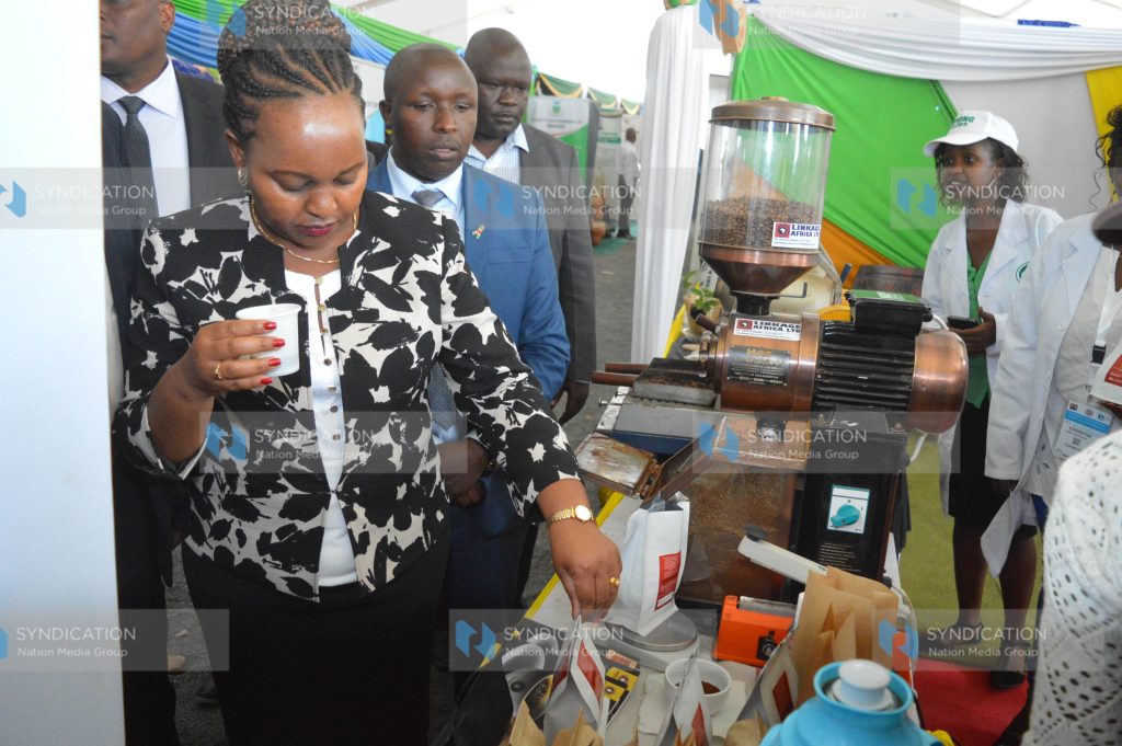 Anne Waiguru samples coffee at the exhibition stands