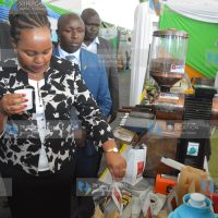 Anne Waiguru samples coffee at the exhibition stands