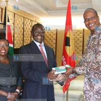 Governor Kiraitu Murungi (center) receives a book from IPOA Vice Chairman
