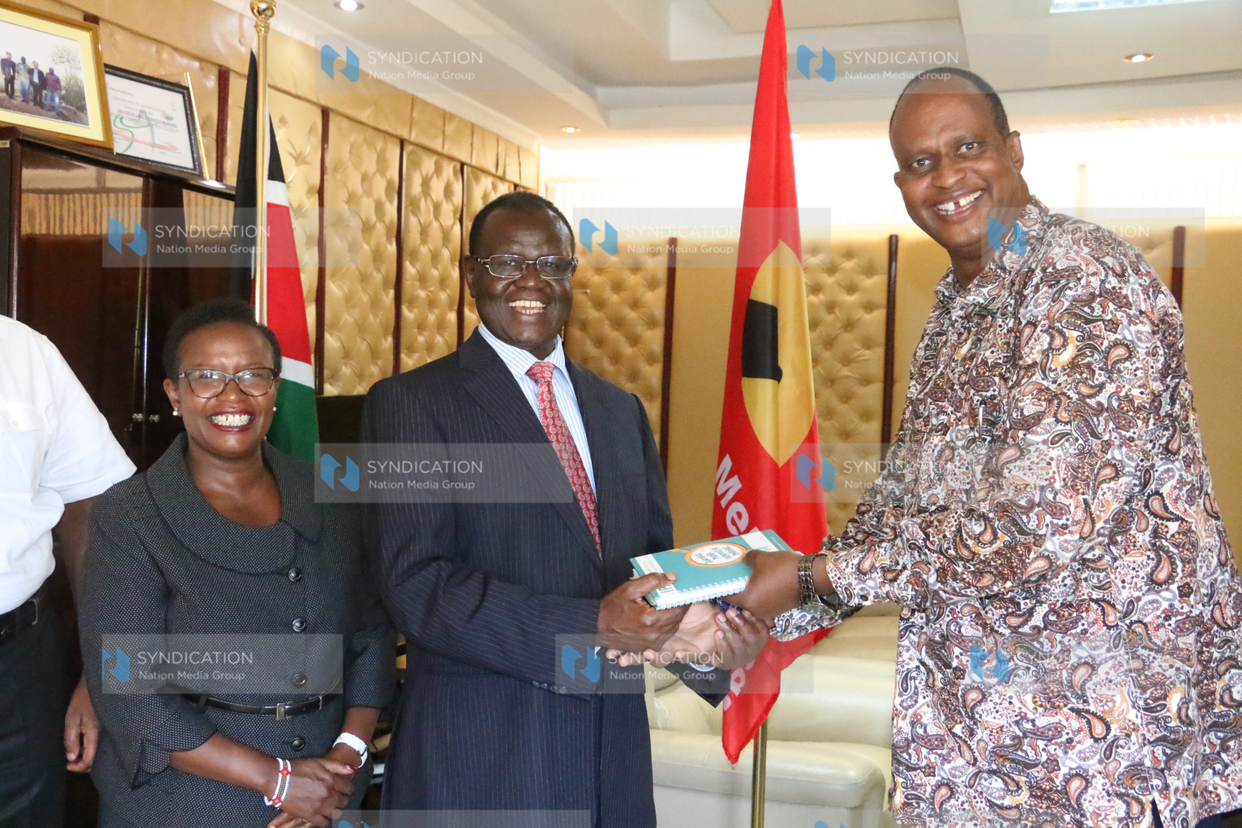 Governor Kiraitu Murungi (center) receives a book from IPOA Vice Chairman