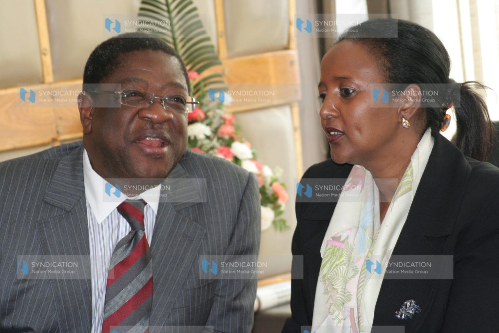 Attorney general Amos Wako chats with justice permanent secretary Amina Mohamed