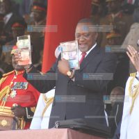 President Uhuru Kenyatta displays the new generation currency notes
