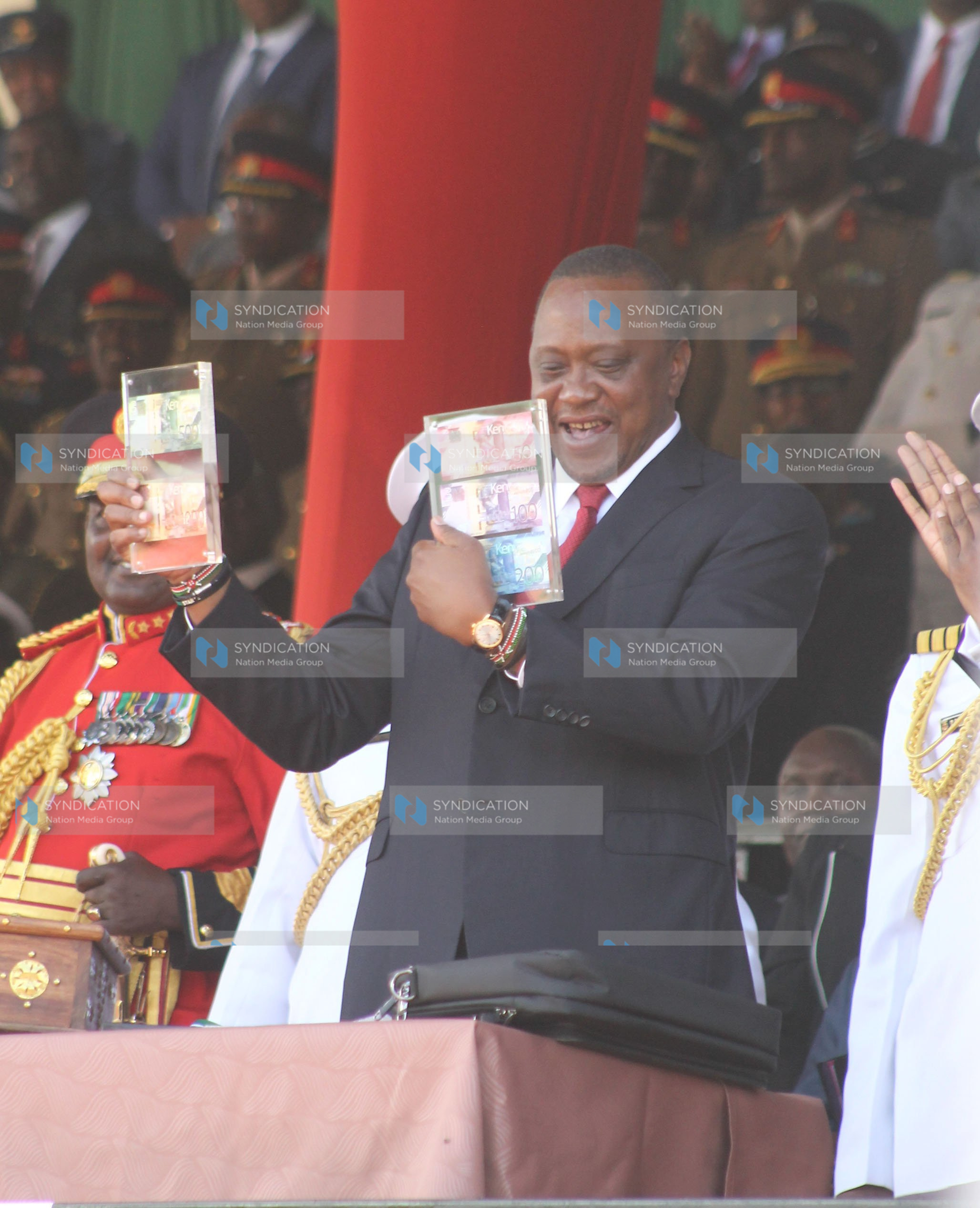 President Uhuru Kenyatta displays the new generation currency notes
