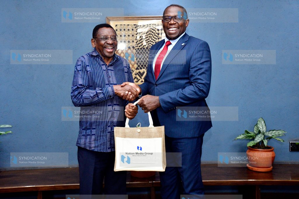 Nation Media Group (NMG) Group Managing Director and CEO Geoffrey Odundo presents a gift to Siaya Governor James Orengo