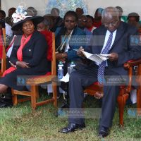 Former President Mwai Kibaki peruses a copy of eulogy
