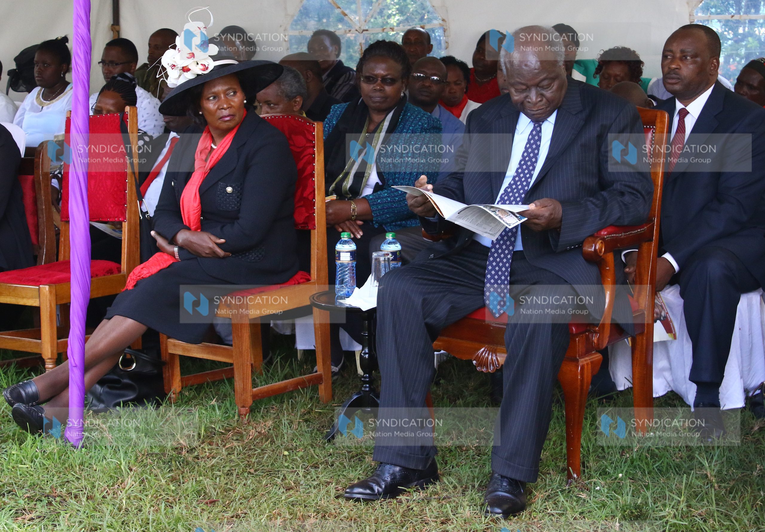 Former President Mwai Kibaki peruses a copy of eulogy