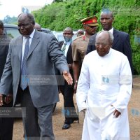 President Mwai Kibaki (center) is accompanied by father James Kihara