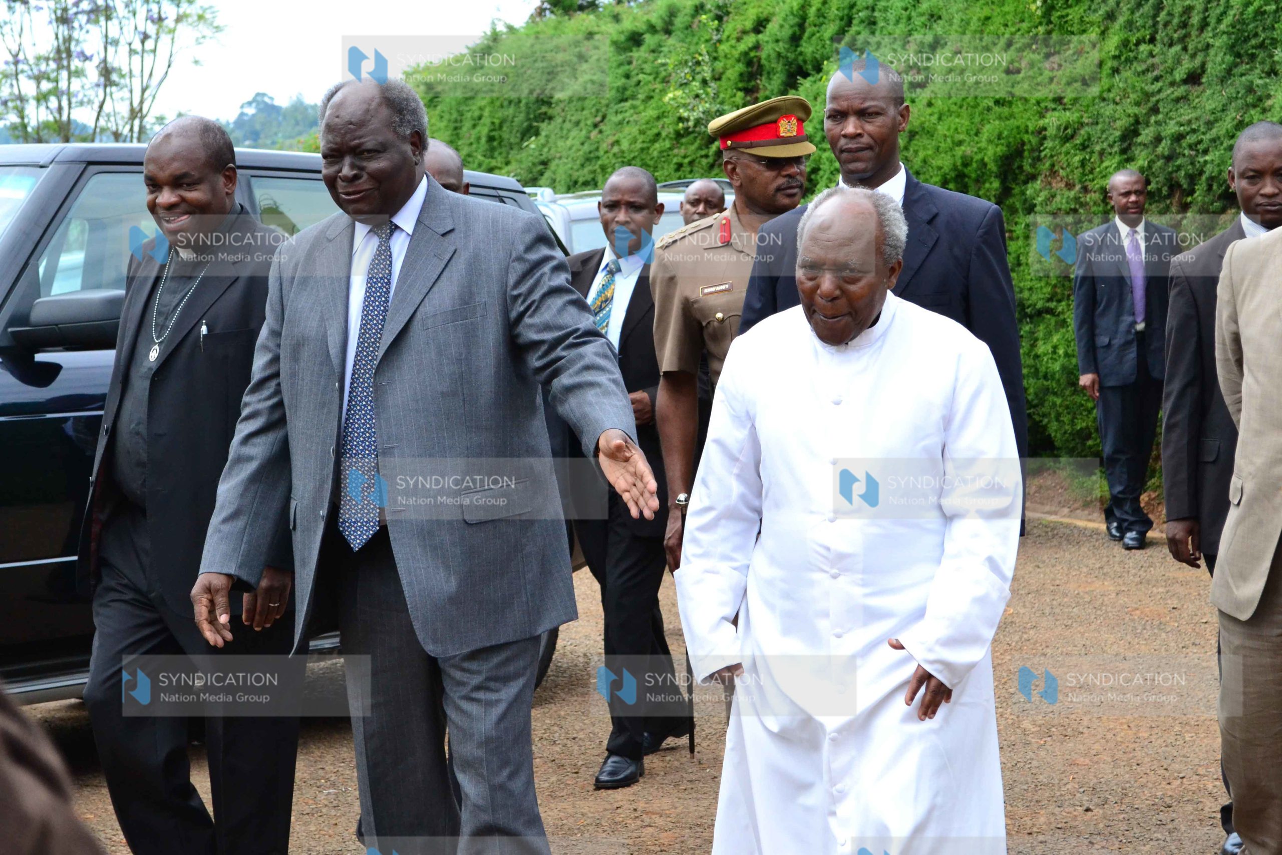 President Mwai Kibaki (center) is accompanied by father James Kihara