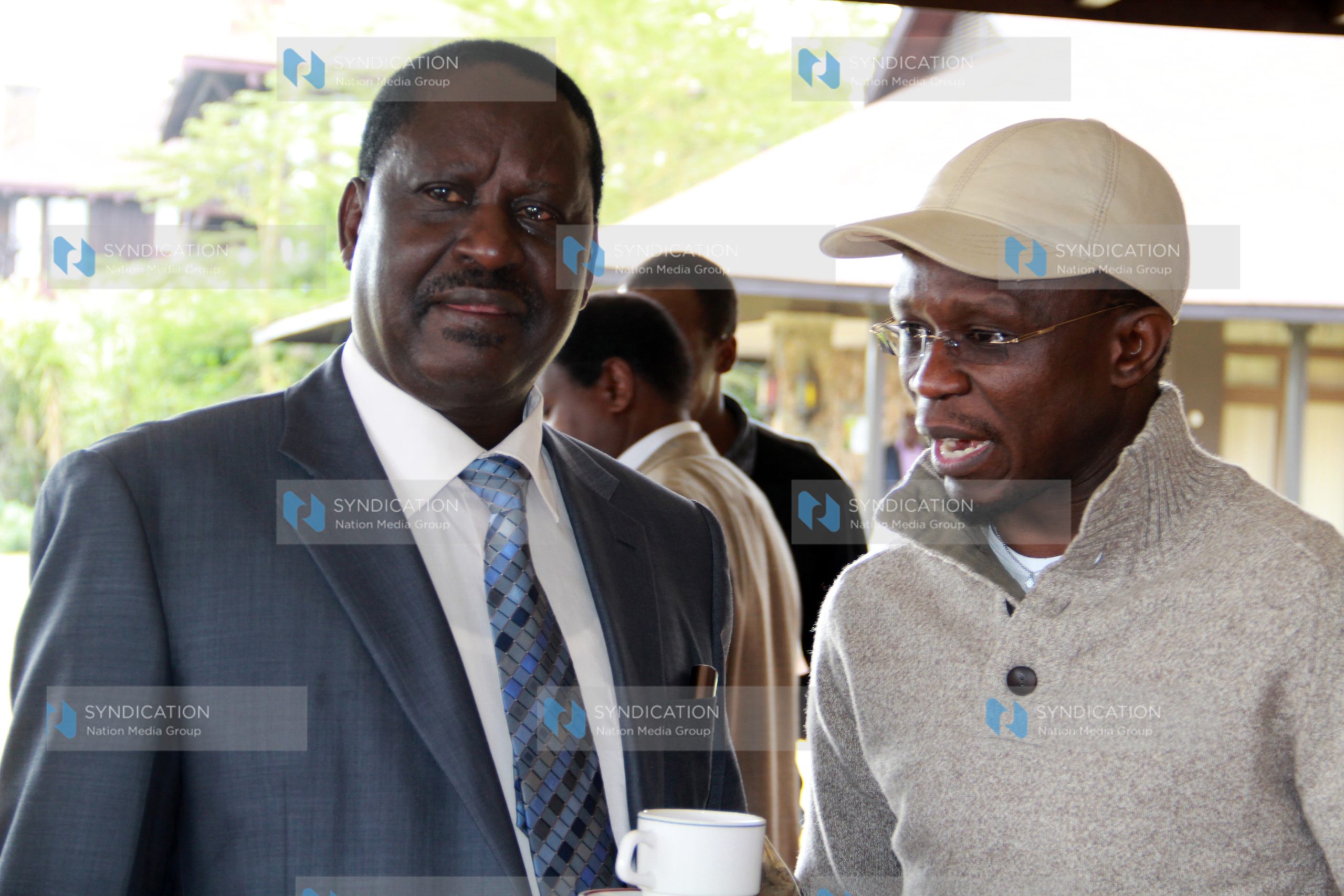 Ababu Namwamba confers with Raila Odinga