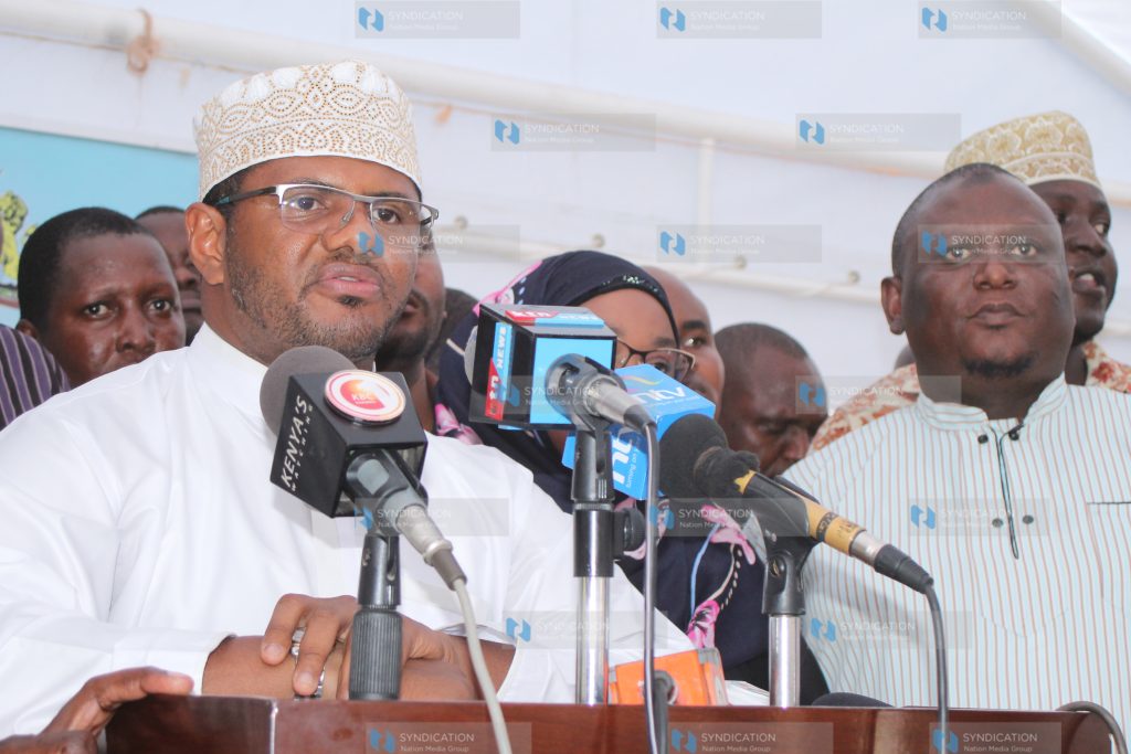 Hassan Omar (centre) addresses the press