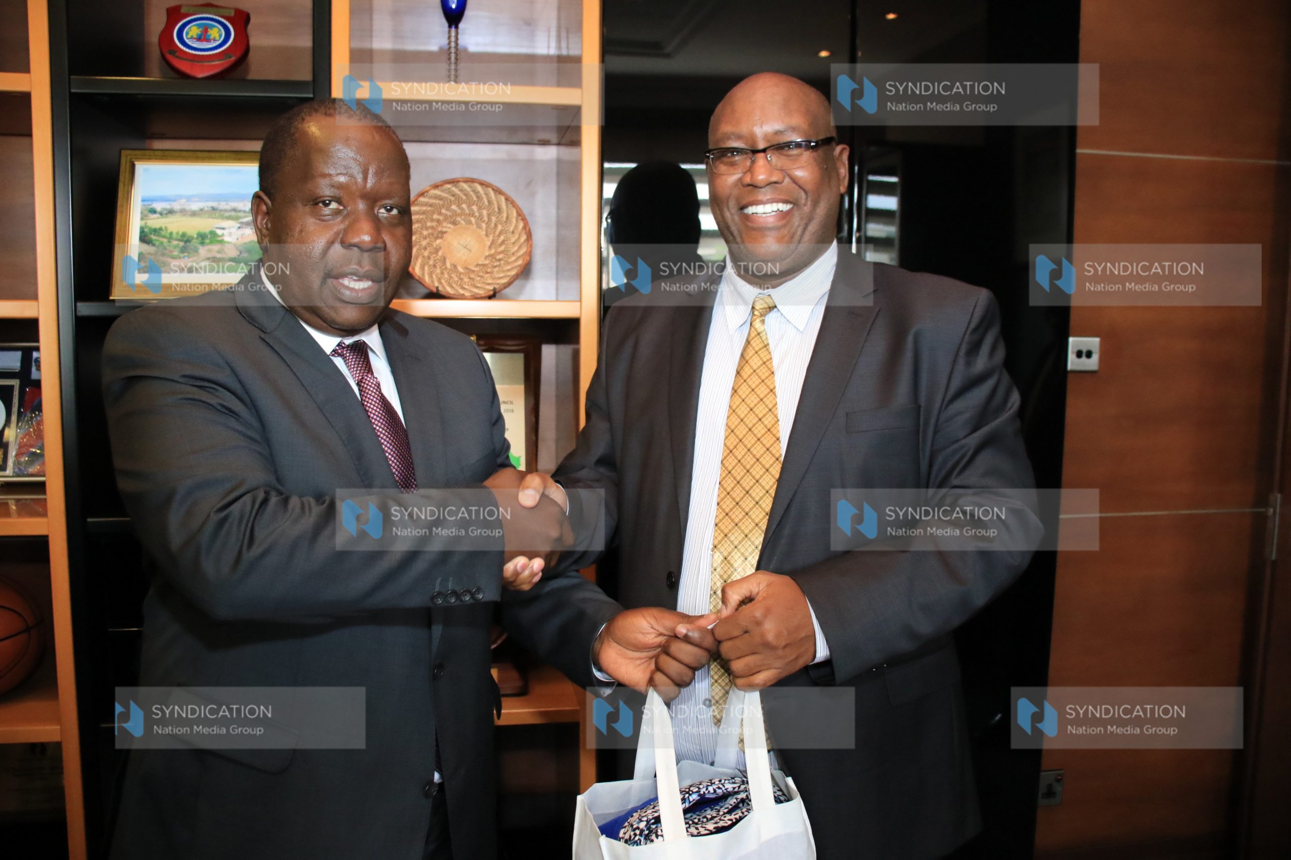 NMG CEO Stephen Gitagama presents a gift to Interior CS Fred Matiang’i