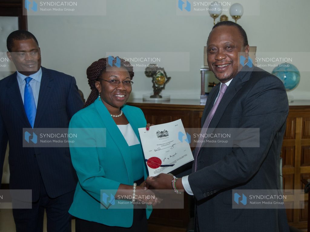 President Uhuru Kenyatta handing over the Engineering Technology Act, 2016 to Bomet Women representative Cecilia Ng'etich
