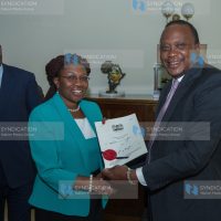 President Uhuru Kenyatta handing over the Engineering Technology Act, 2016 to Bomet Women representative Cecilia Ng'etich