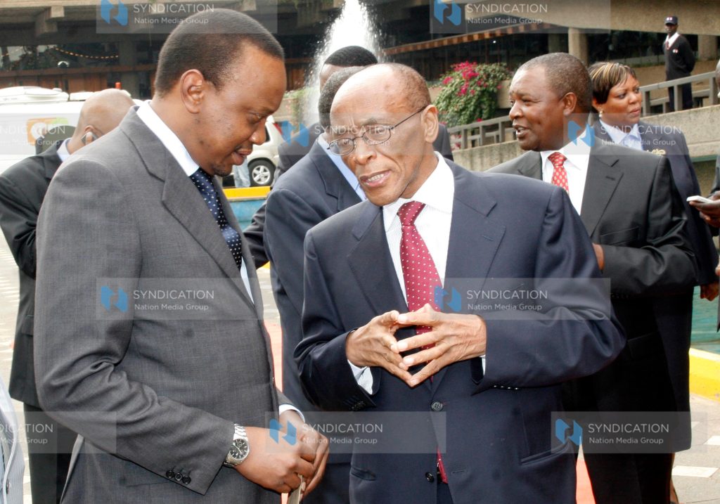 Deputy Prime Minister and Minister for Finance Uhuru Kenyatta confers with Family Bank Chairman Titus Muya