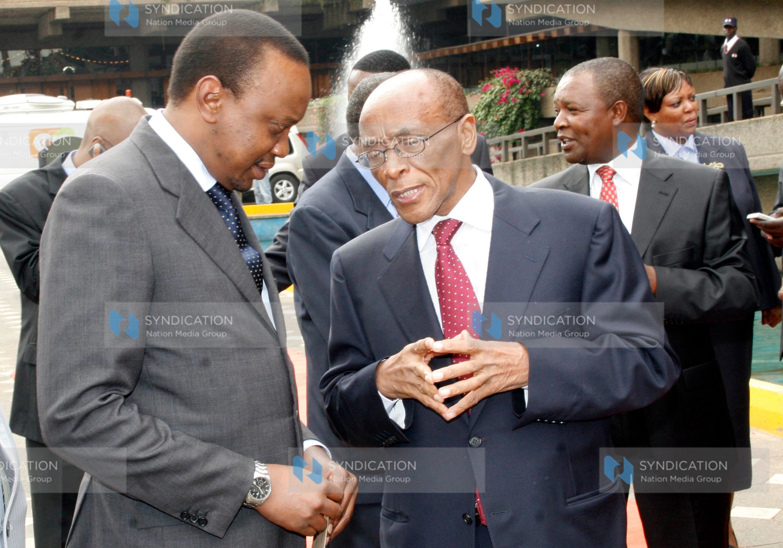 Deputy Prime Minister and Minister for Finance Uhuru Kenyatta confers with Family Bank Chairman Titus Muya