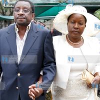 Rose Kajwang’, widow of the late Homa Bay Senator Otieno Kajwang’, is led to a car by Senator James Orengo