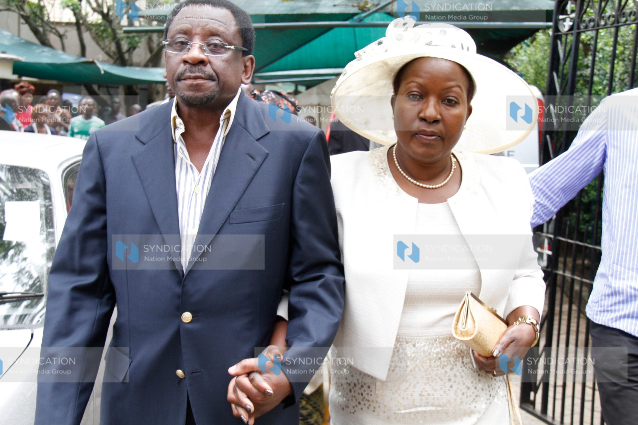 Rose Kajwang’, widow of the late Homa Bay Senator Otieno Kajwang’, is led to a car by Senator James Orengo