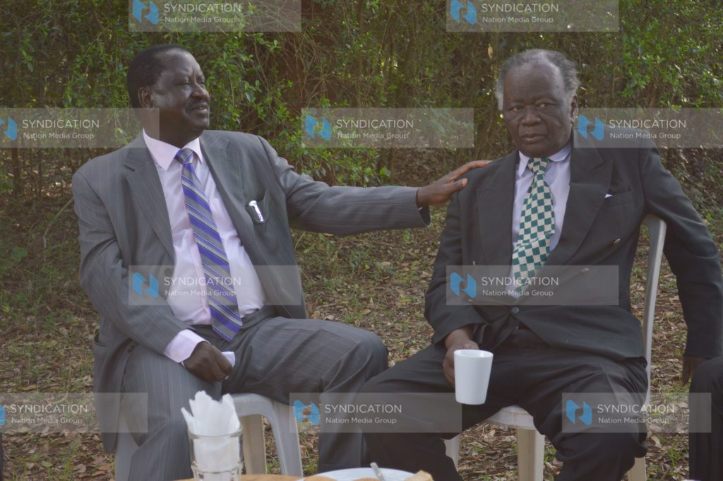 Raila Odinga (left) consoles John Khaminwa