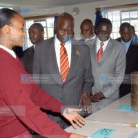 Angela Ewang (left) shows former President Daniel arap Moi some of the farming and poultry equipment