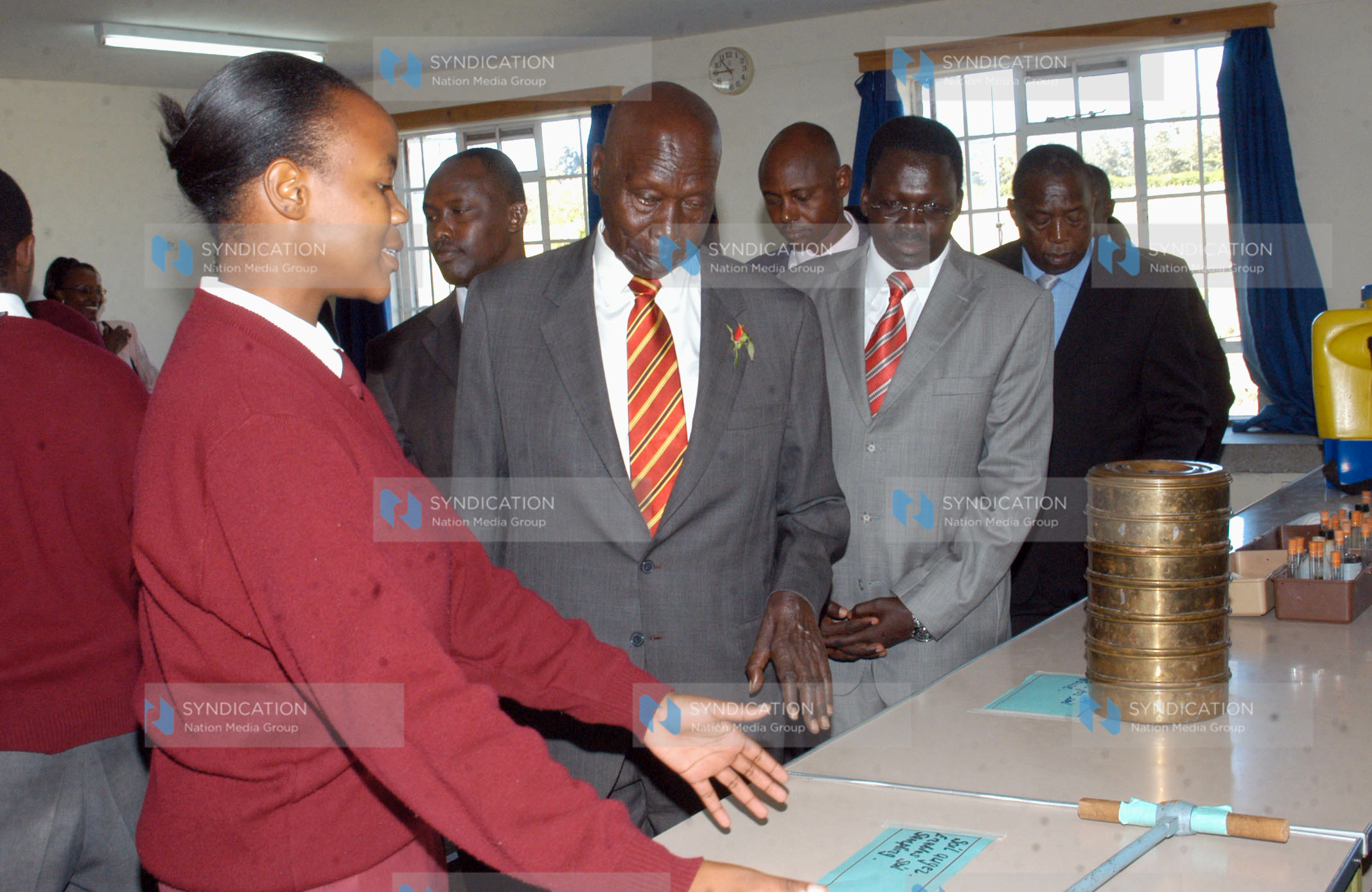 Angela Ewang (left) shows former President Daniel arap Moi some of the farming and poultry equipment