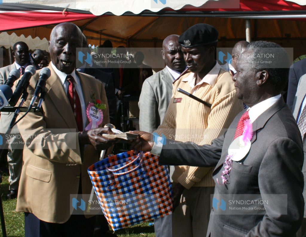 Former President Daniel arap Moi receives a donation from Mr. Nicholas Biwott