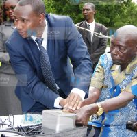 Former President Daniel arap Moi (R) being taken through voter registration exercise