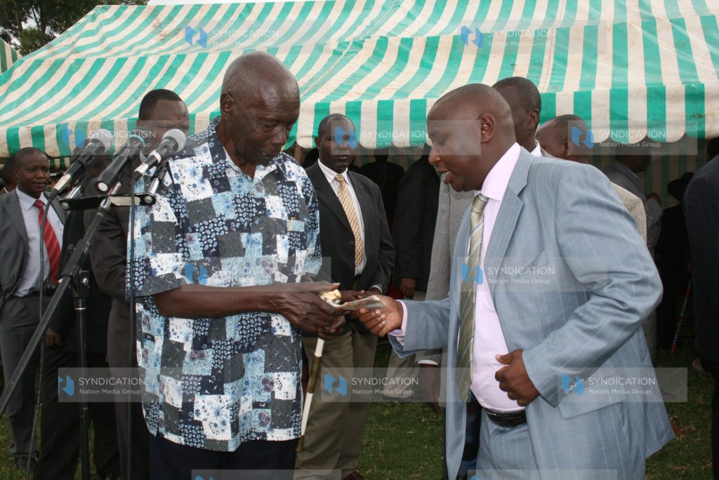 Former President Daniel arap Moi receives a donation from Mr. Hilary Kosgei