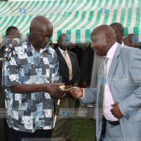 Former President Daniel arap Moi receives a donation from Mr. Hilary Kosgei