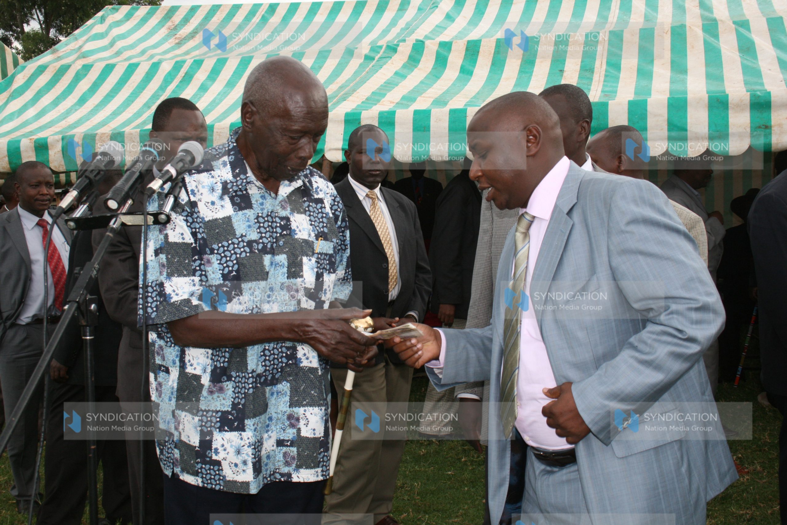 Former President Daniel arap Moi receives a donation from Mr. Hilary Kosgei