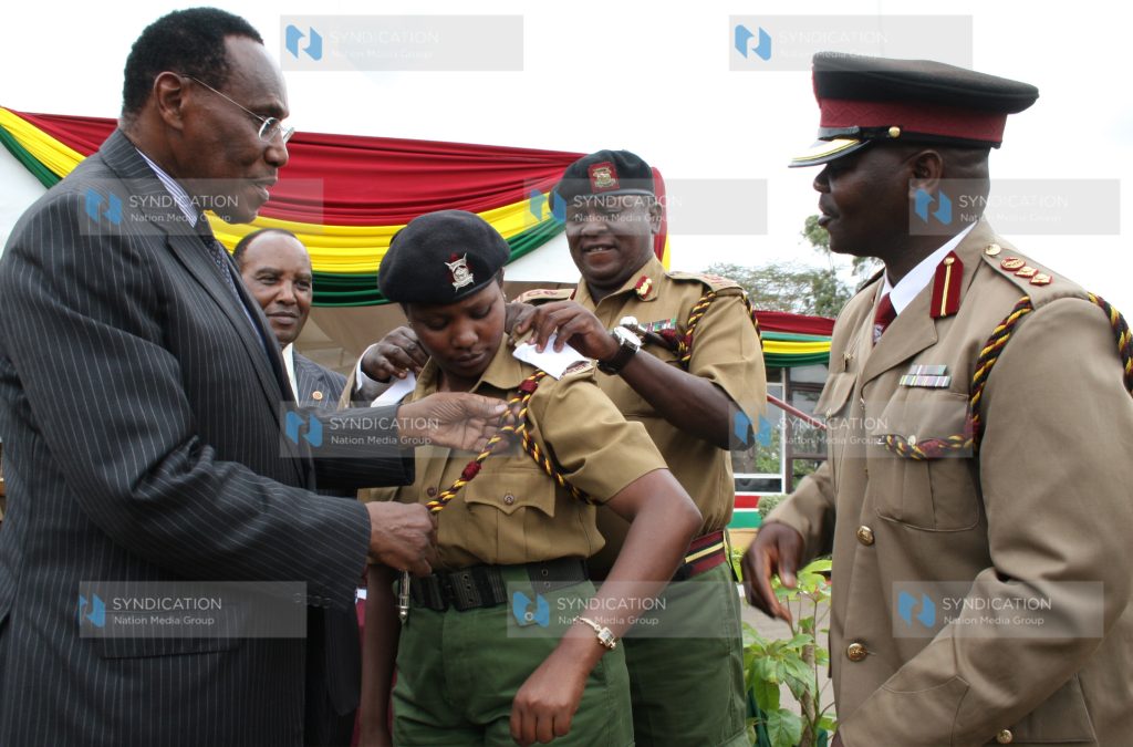 Minister for Internal Security Prof. George Saitoti decorates Senior Superintendent of Police Margaret Karanja from Chief Inspector