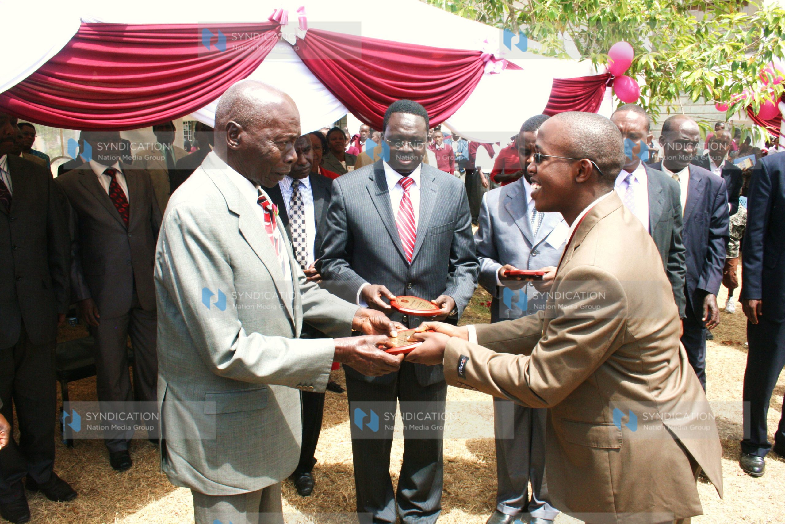 Former President Daniel Arap Moi presents a trophy to the top national KCSE student in the 2010 exams