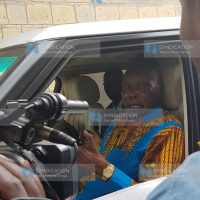 Retired President Daniel Arap Moi chats with a polling clerk after voting