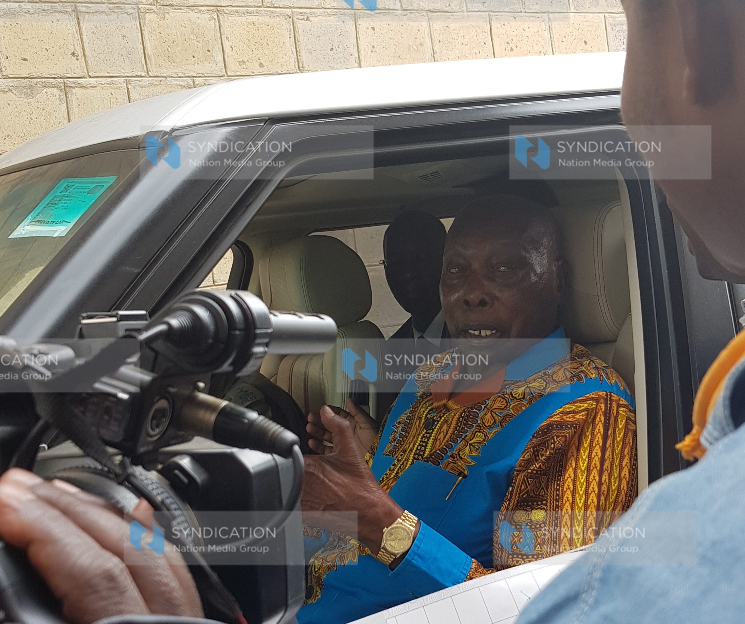Retired President Daniel Arap Moi chats with a polling clerk after voting