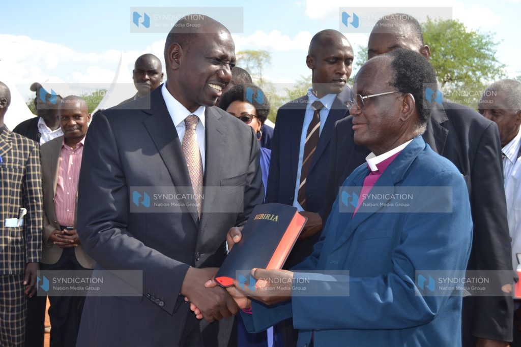 Deputy President Dr William Ruto receives a Kitharaka language bible from retired Kenya Methodist Church presiding bishop Dr Stephen Kanyaru
